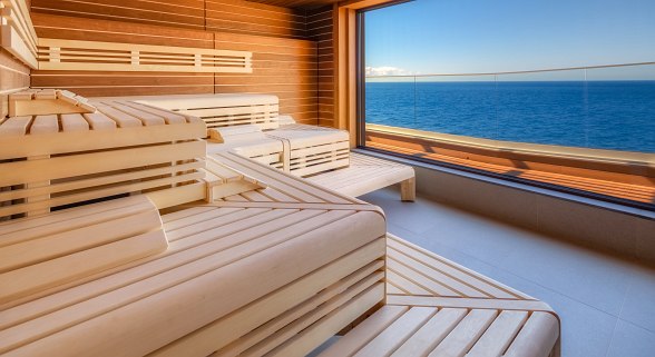 Moderne Sauna mit Panoramafenster und beeindruckendem Meerblick für entspannte Wohlfühlmomente.