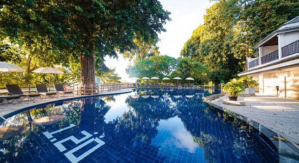 Luftaufnahme des tropischen Resorts Sentido Khao Lak mit mehreren Gebäuden, Swimmingpools, Palmen und Sonnenliegen in grünem Dschungel.