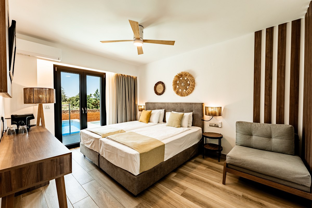 Modernes Hotelzimmer mit Doppelbett, Holzdetails, Schreibtisch, Sofa und direktem Zugang zum privaten Pool.