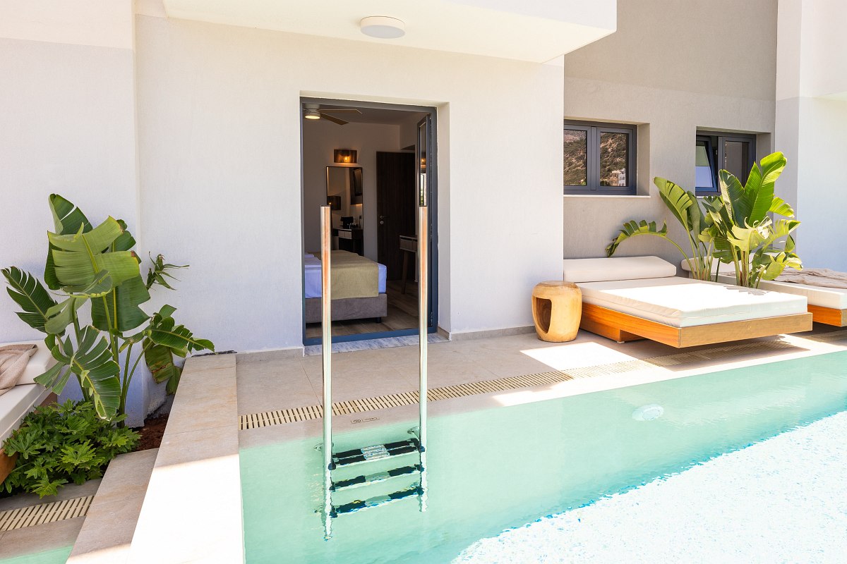Helles Hotelzimmer mit direktem Zugang zum privaten Pool, Liegen, tropischen Pflanzen und moderner Einrichtung.
