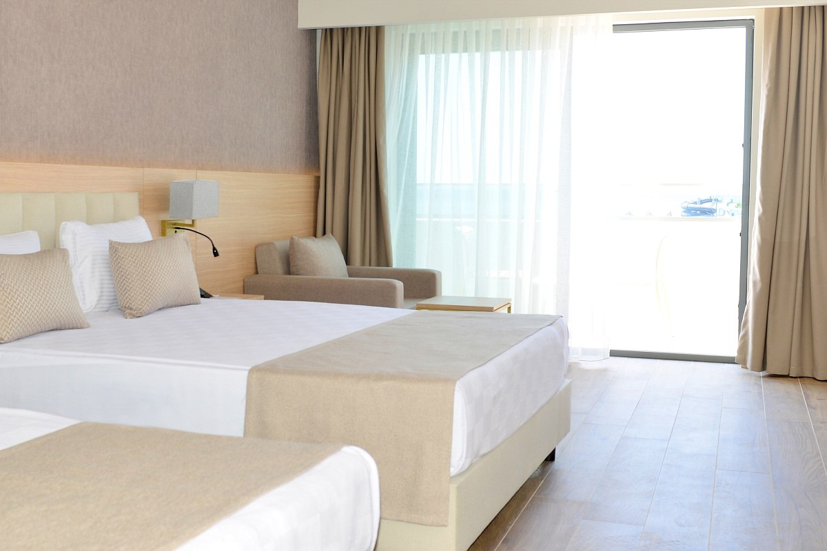 Modernes Familienzimmer mit getrennten Schlafbereichen, stilvollem Design, Teppichboden und Zugang zum Balkon mit Tageslicht.