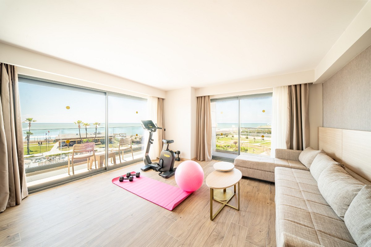 Modernes Familienzimmer mit getrennten Schlafbereichen, stilvollem Design, Teppichboden und Zugang zum Balkon mit Tageslicht.