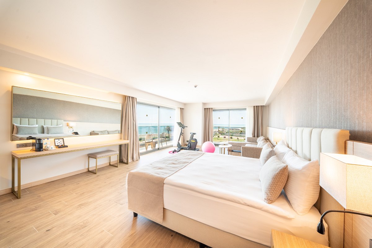 Modernes Familienzimmer mit getrennten Schlafbereichen, stilvollem Design, Teppichboden und Zugang zum Balkon mit Tageslicht.