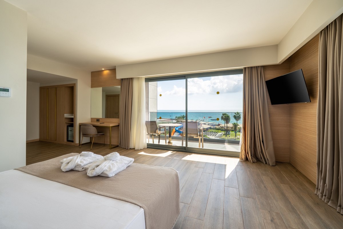 Modern eingerichtetes Doppelzimmer mit Kingsize-Bett, Schreibtisch, Flachbild-TV und gemütlicher Sitzecke.