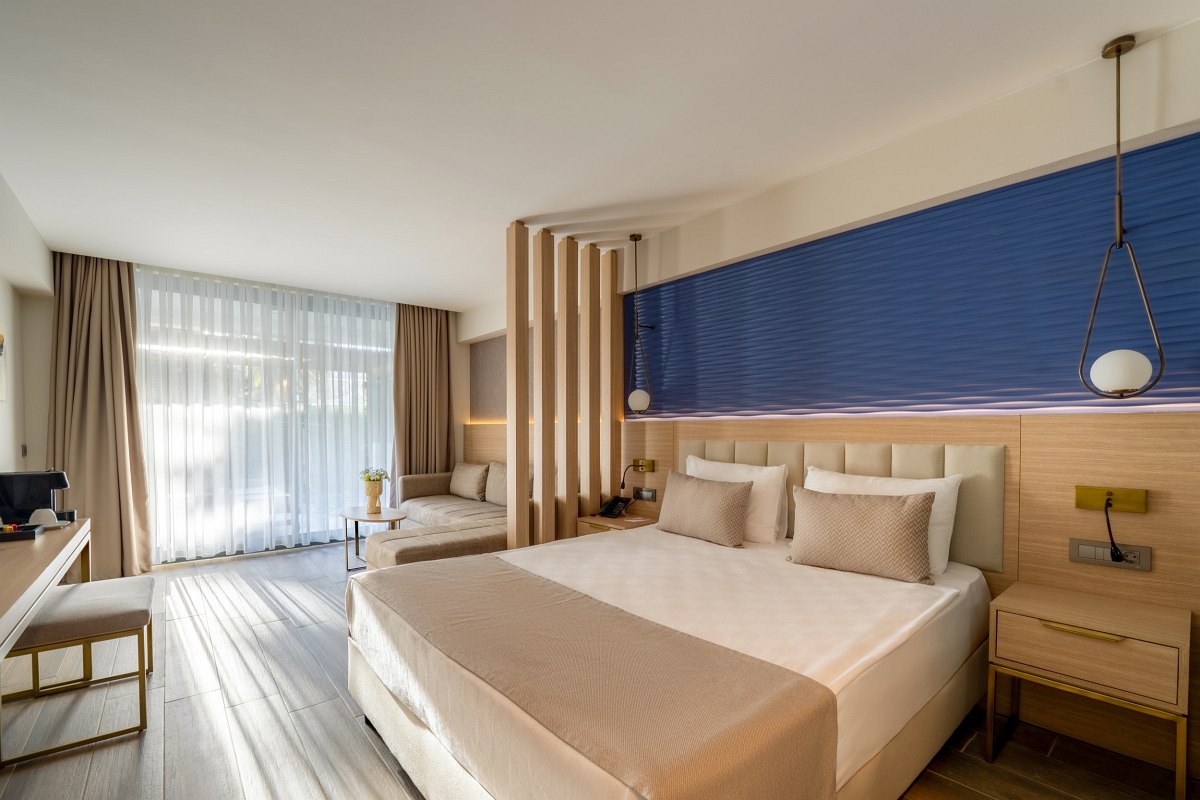 Modern eingerichtetes Doppelzimmer mit Kingsize-Bett, Schreibtisch, Flachbild-TV und gemütlicher Sitzecke.