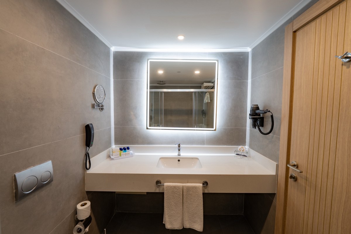 Modernes Hotelbad mit Glasdusche, edlem Marmorwaschtisch und hochwertigen Pflegeprodukten.