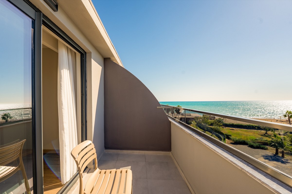 Helles Familienzimmer mit zwei separaten Schlafbereichen, modernem Design, Schreibtisch und Balkonzugang.