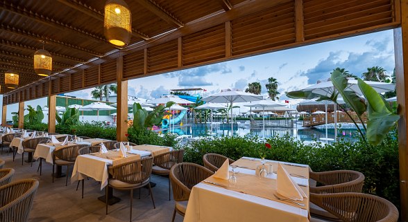 Luftaufnahme einer weitläufigen Hotelanlage mit Pools, Rutschen, Sonnenschirmen und orientalischer Architektur.