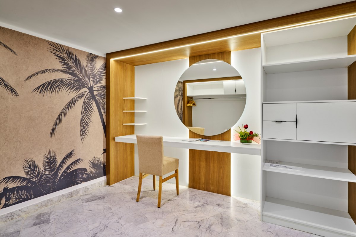 Modernes Hotelzimmer mit großem Bett, gemütlichem Sofa, stilvoller Beleuchtung und hellem, minimalistischen Design.