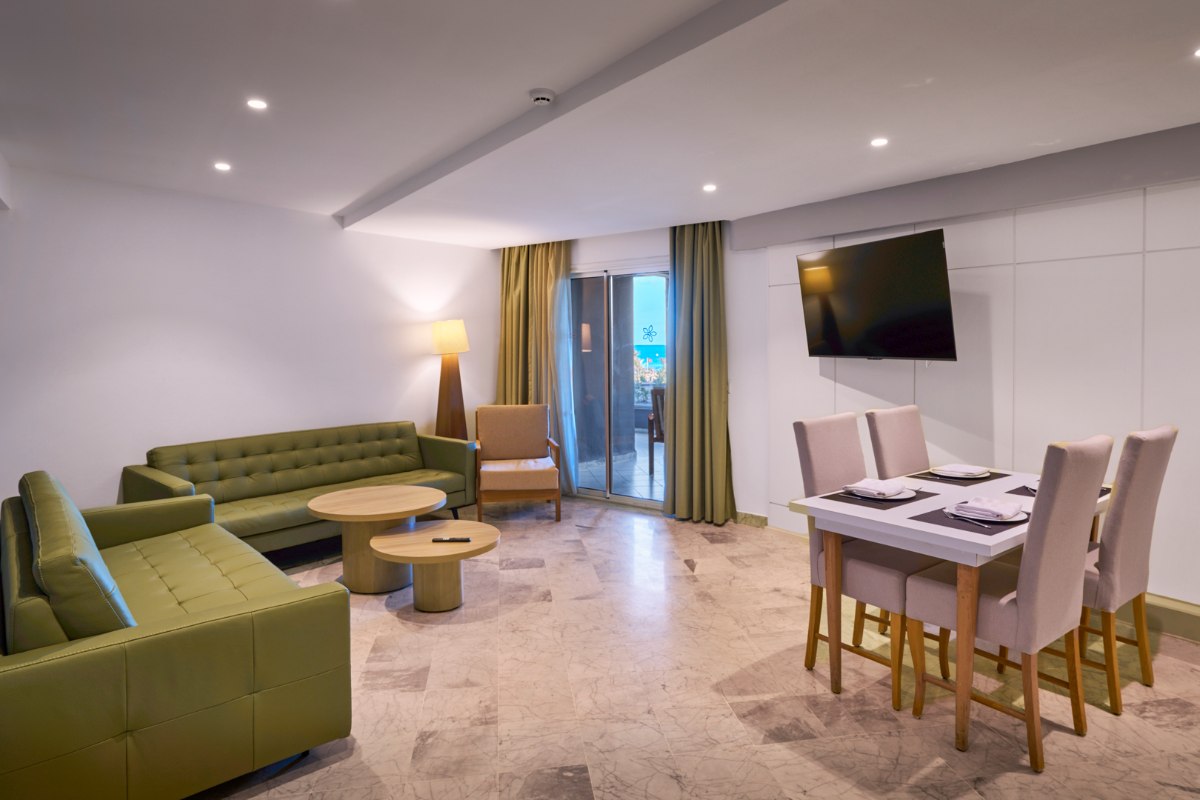 Hotelzimmer mit modernem Design, großem Bett, Kamin und Balkon, hell und minimalistisch eingerichtet.