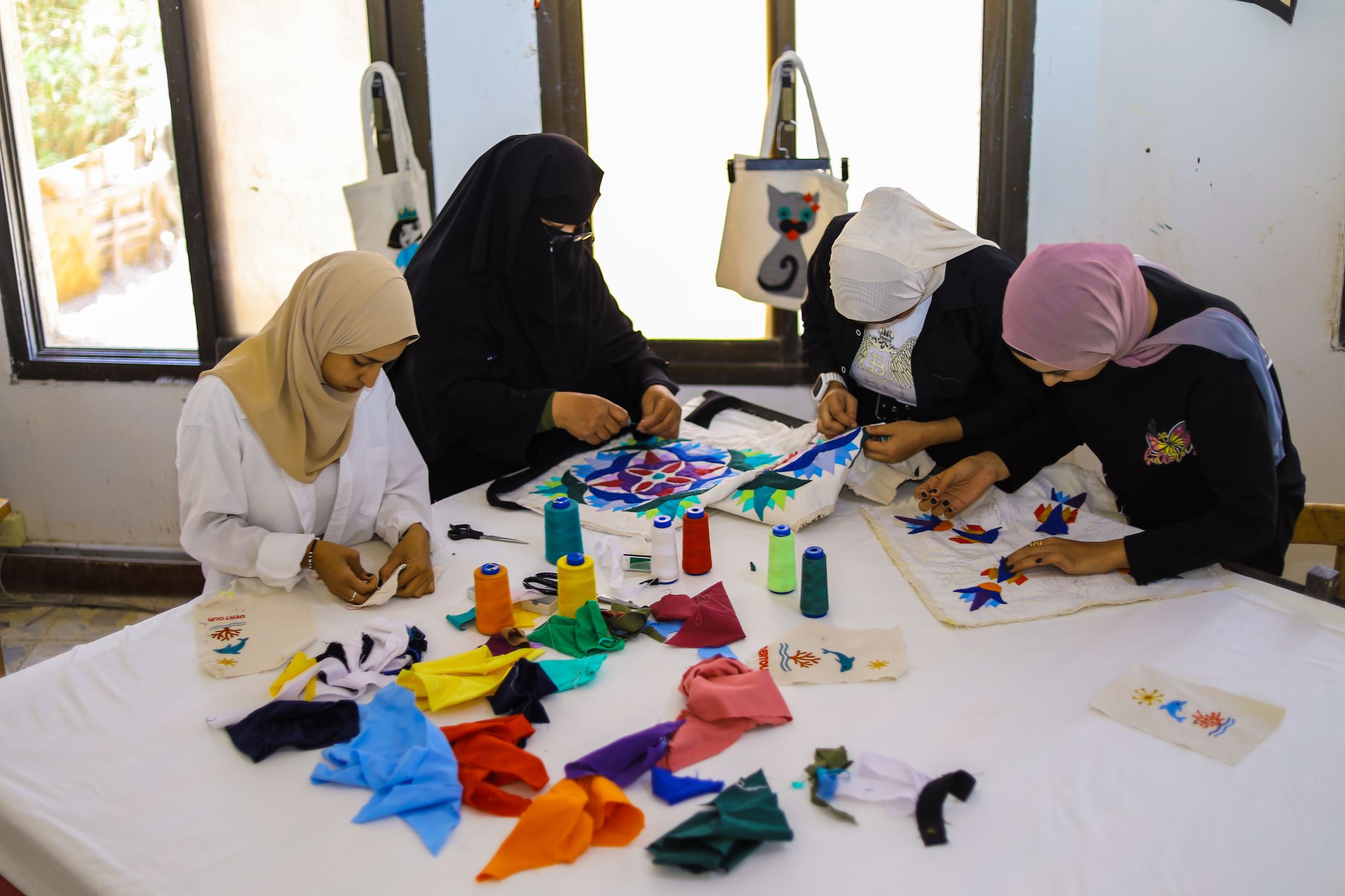 „Geräumige Restaurantterrasse mit Holztischen, Blick auf den Sandstrand und das Meer unter blauem Himmel.“