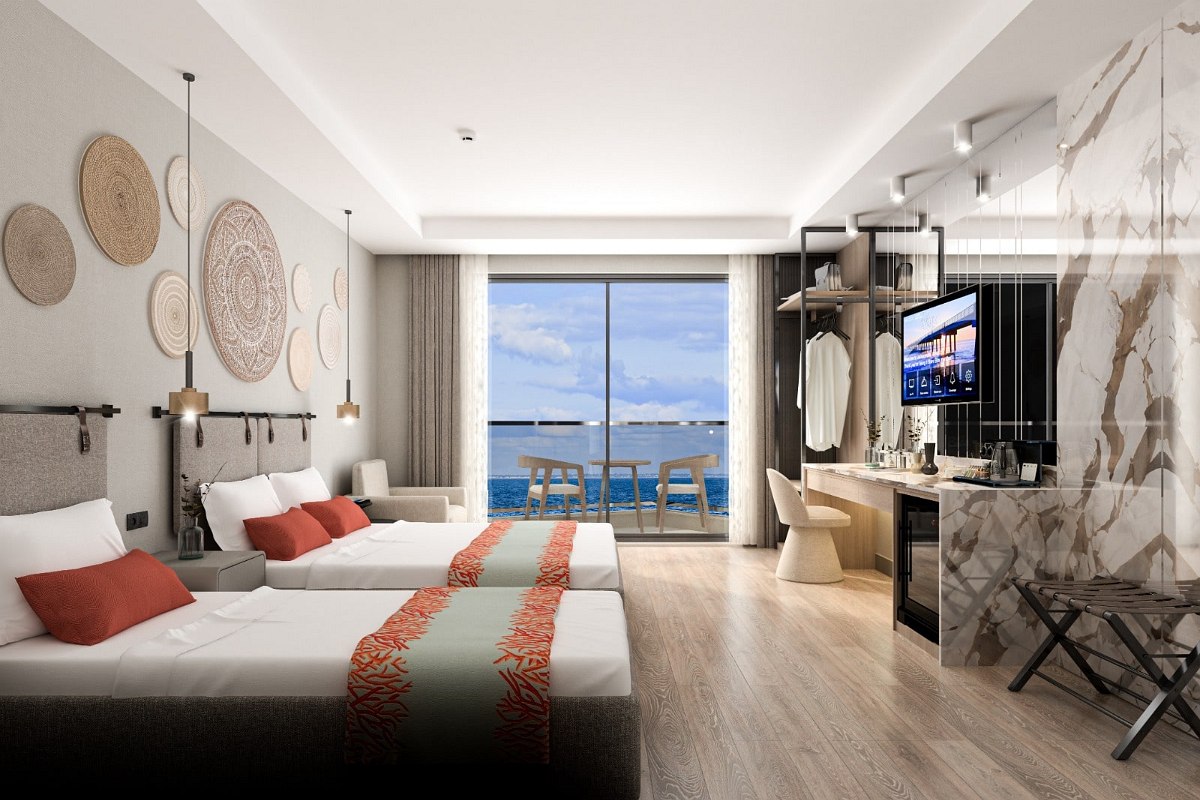 Elegantes Hotelzimmer mit zwei Betten, stilvollem Interieur und Balkon mit traumhaftem Meerblick bei Abenddämmerung.