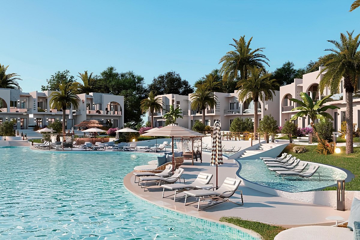 Abendliche Stimmung in einer Hotelanlage mit burgähnlicher Architektur, beleuchtetem Pool, Palmen und stimmungsvoller Spiegelung im Wasser.