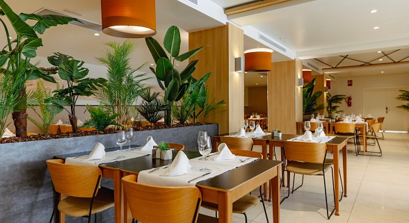 Cozy restaurant with maritime decoration, checkered tablecloths, white furniture and laid tables.