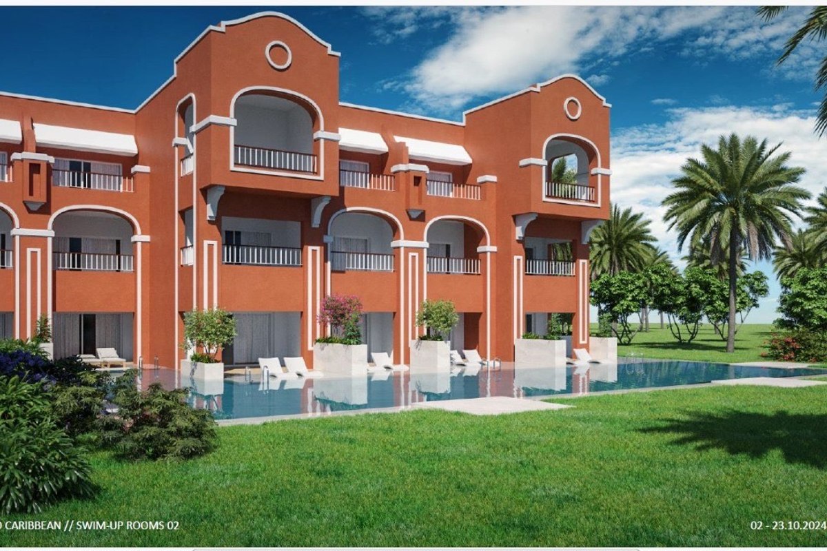 Modern resort building with poolside rooms, private pools, surrounded by palm trees and green lawns under a blue sky.