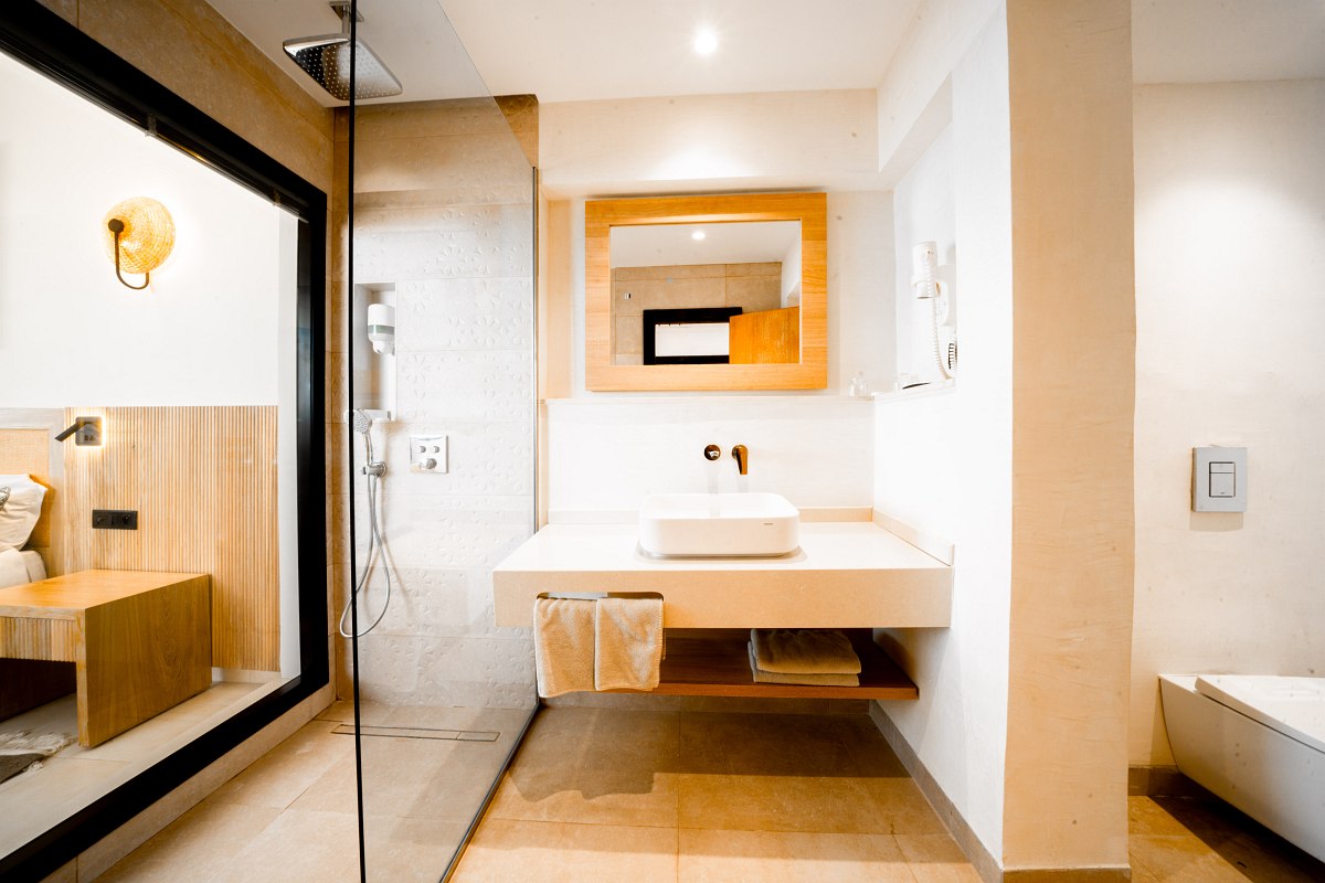 Comfortable hotel room with double bed, desk, wall lighting and subtle decor.