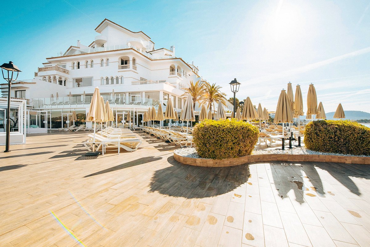 Front view of the Sentido Fido Punta del Mar hotel, white Majorcan-style building, sun parasols
