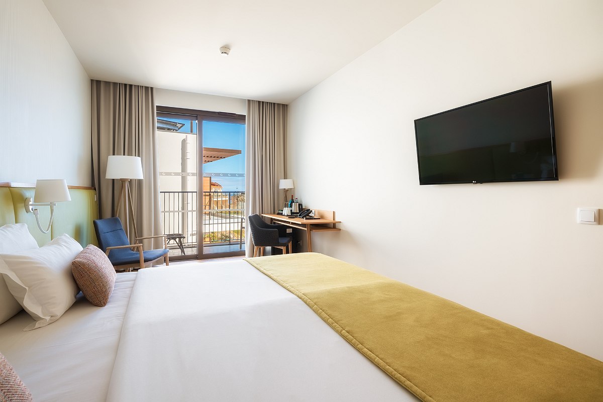 Bright, modern room with balcony, desk, TV and stylish accents - ideal for relaxing and working.