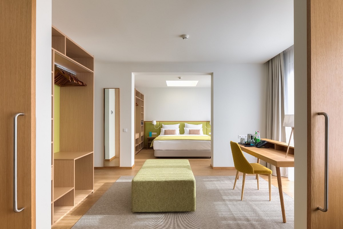 Spacious suite with open closet, stylish work area and modern bedroom in natural design.