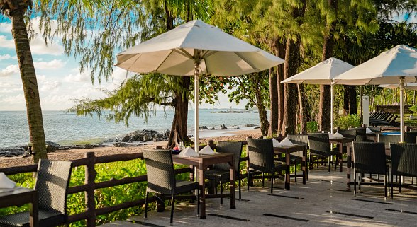  Terrace restaurant of Hotel Sentido Khao Lak with covered tables, parasols and sea views at sunset.