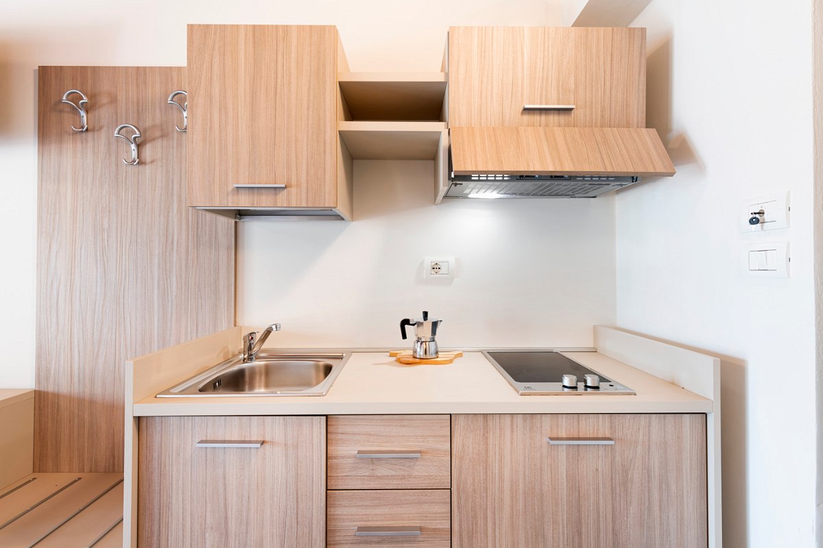 Well-equipped kitchenette with sink, fridge, hob and storage space.