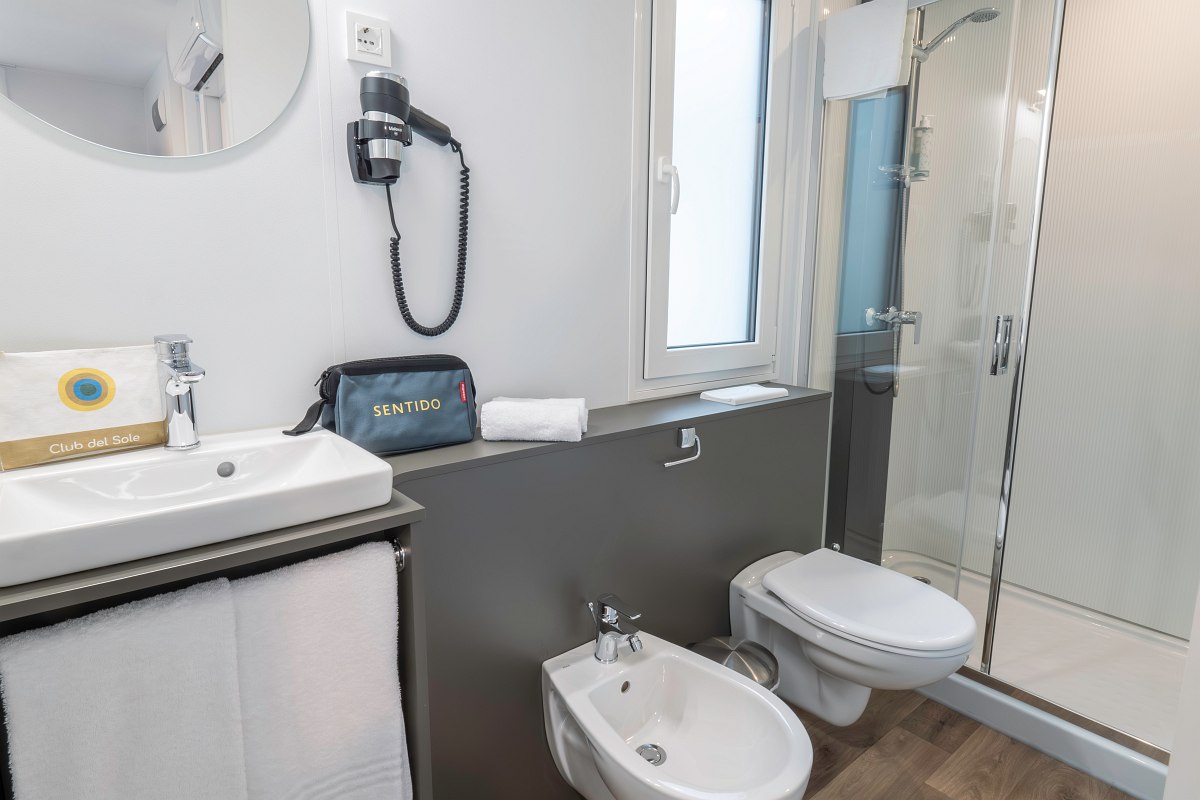Modern bathroom with shower, WC, bidet, washbasin, window and hairdryer - bright and functionally equipped.