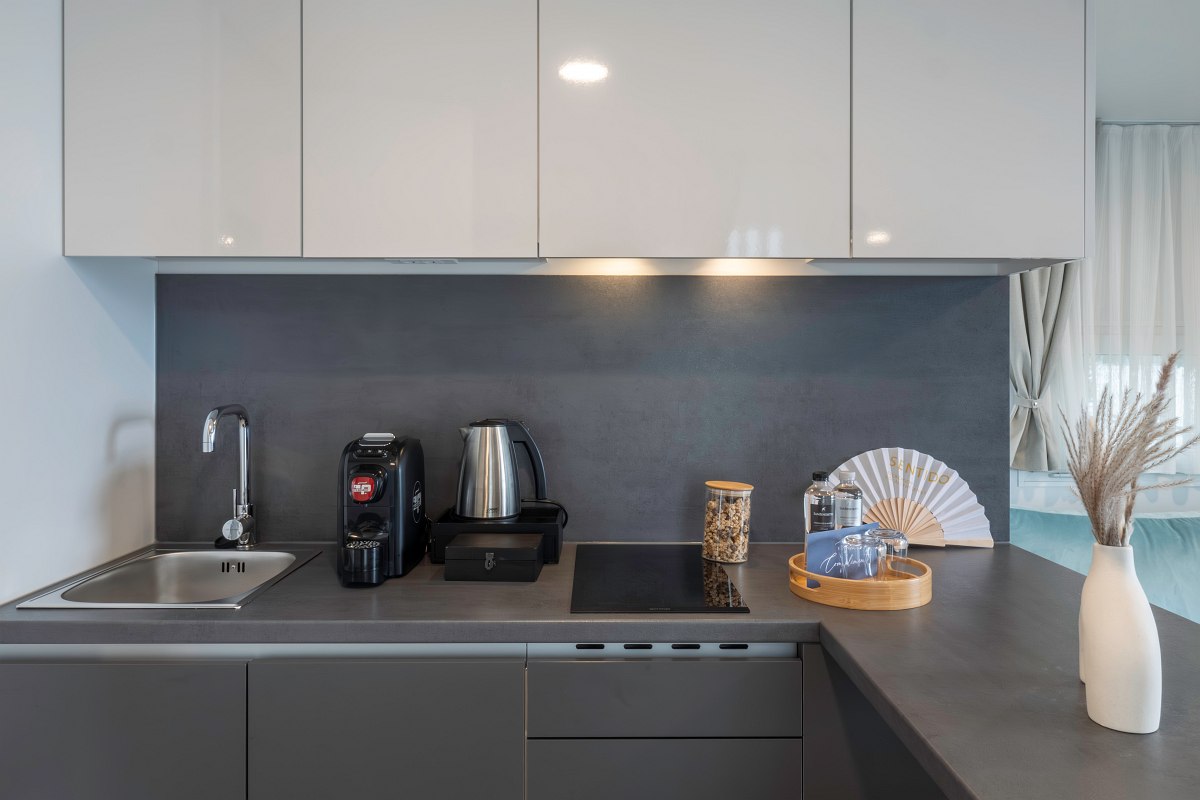 Modern, fully equipped kitchenette with kettle, hob, sink and coffee machine.