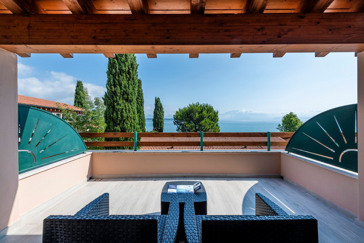 Roofed Balcony with hillside-view and comfortable seating furniture.