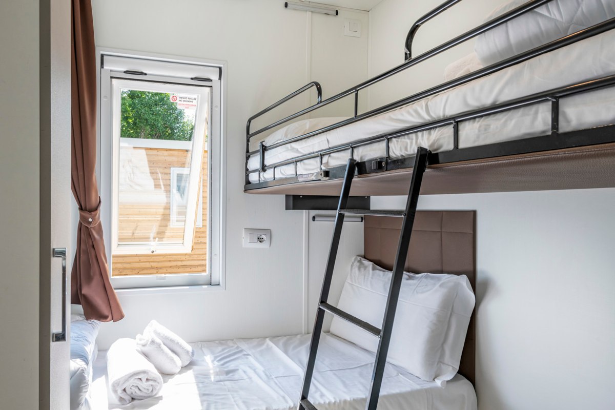Small bedroom with bunk bed, ladder, window and daylight - ideal for children or two people.