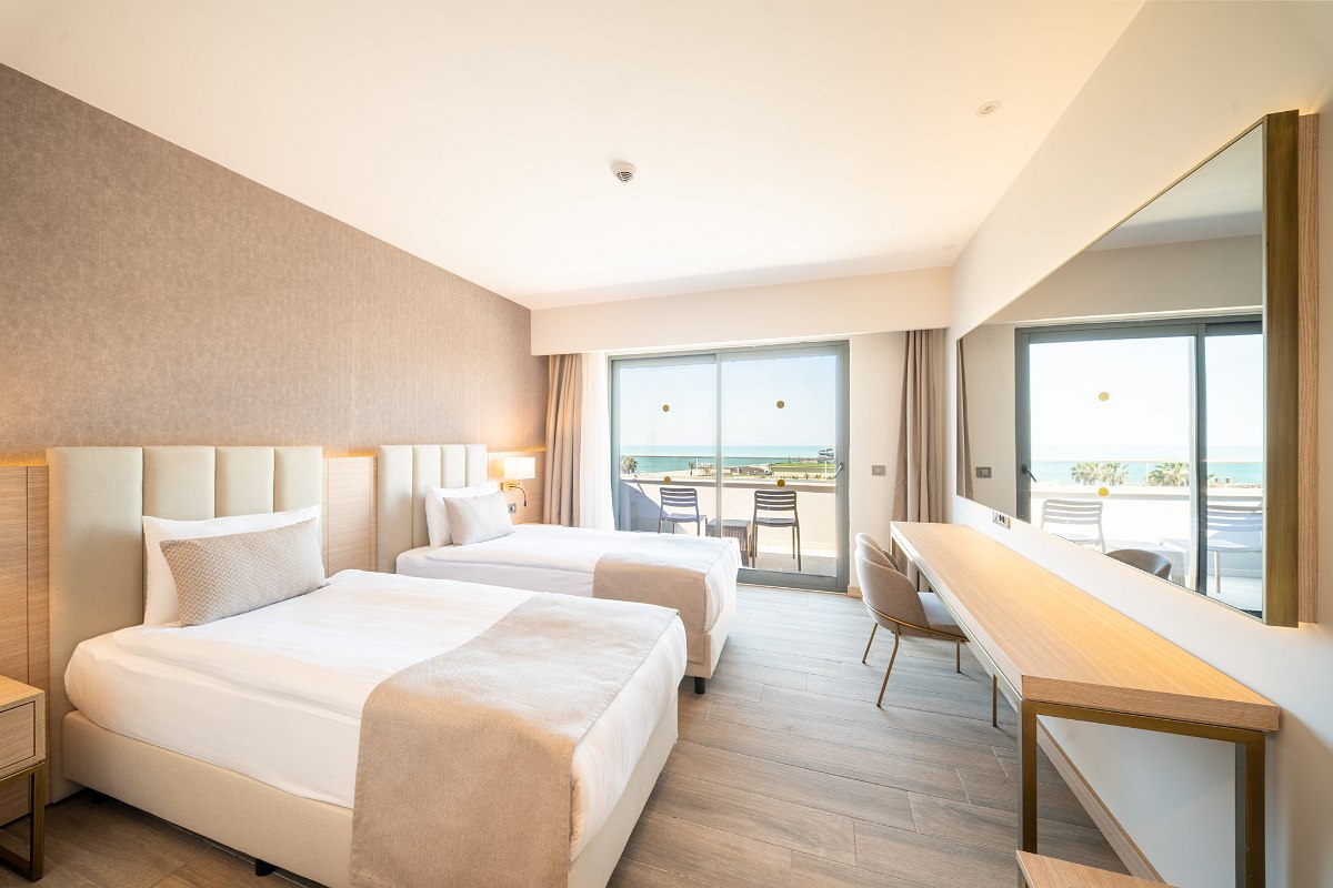 Suite Jacuzzi with balcony and sea view, modern furnishings with TV, seating area and stylish decor.