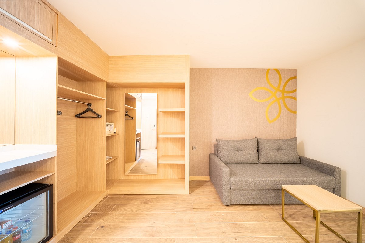 Bright family room with two separate sleeping areas, modern design, desk and balcony access.