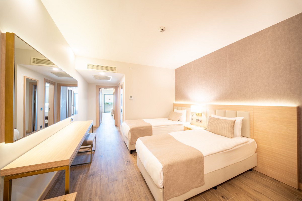 Modern double room with king-size bed, desk, flat-screen TV and cozy seating area.