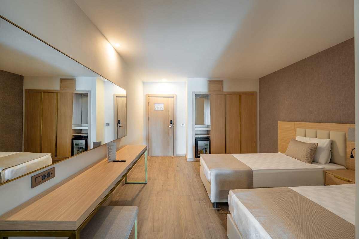 Double room with balcony and sea view, modern furnishings with TV, seating area and stylish decor.