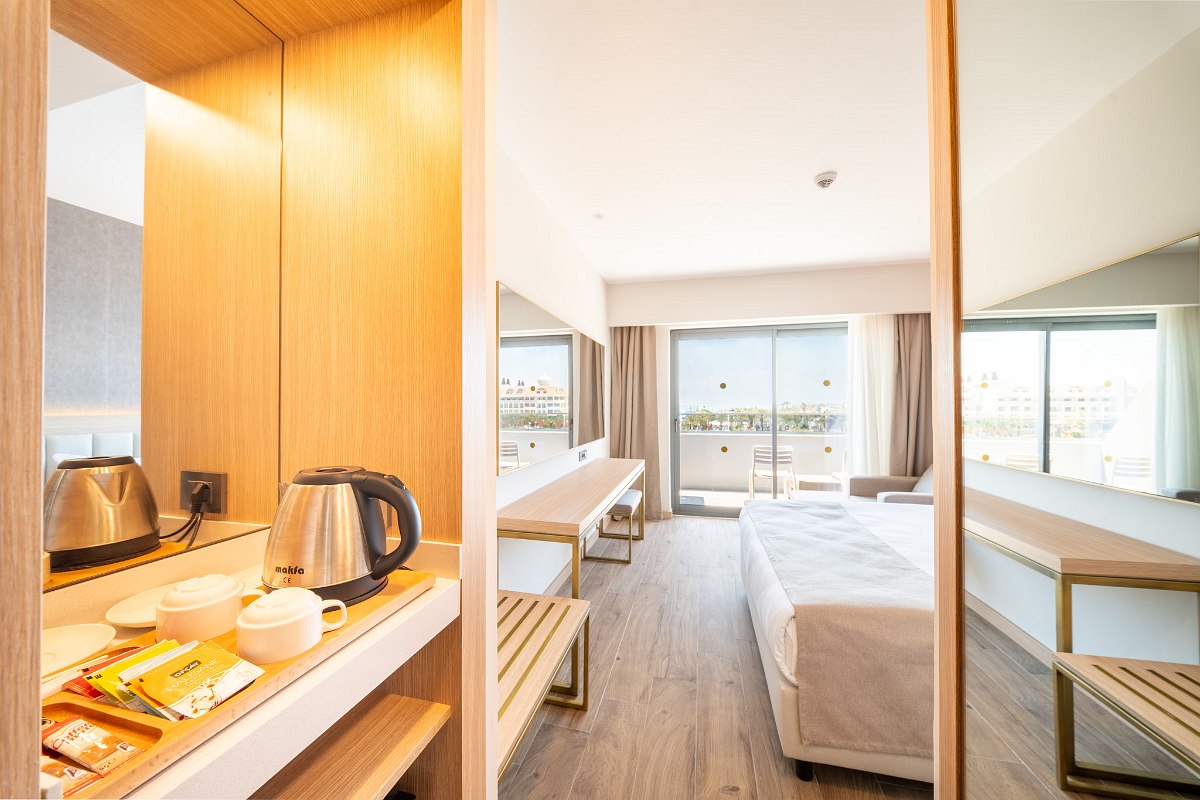 Double room with balcony and sea view, modern furnishings with TV, seating area and stylish decor.