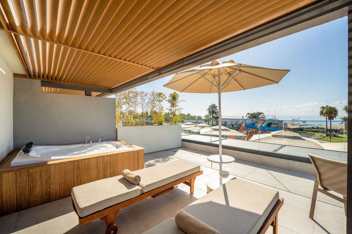 Modern double room with king-size bed, desk, flat-screen TV and cozy seating area.