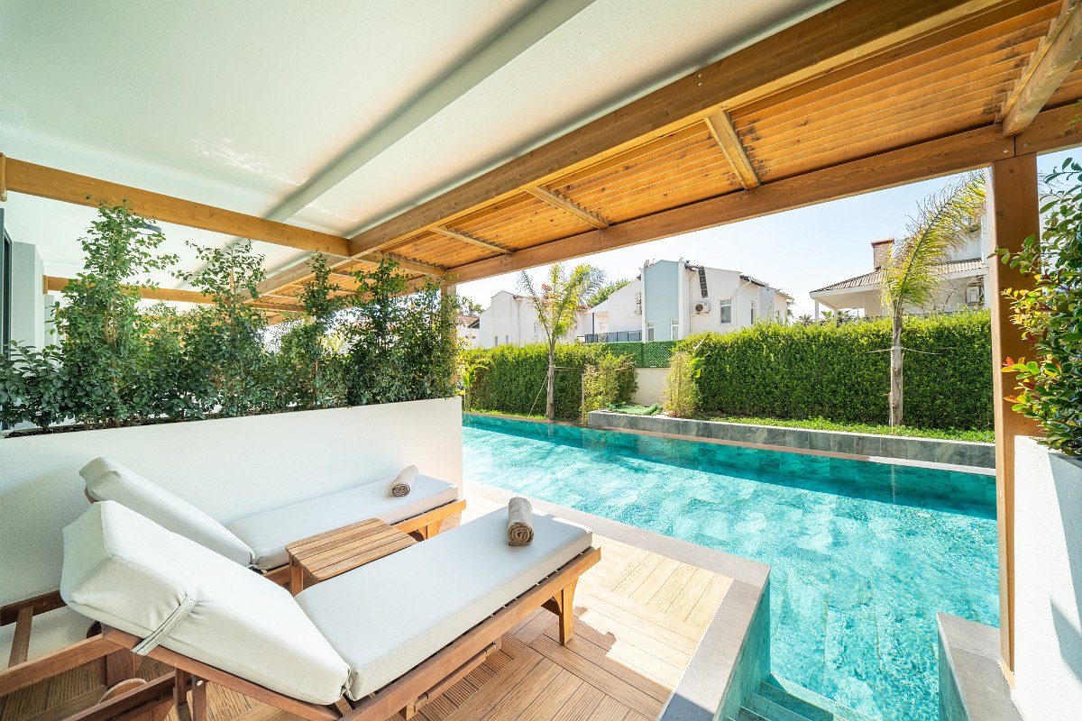 Elegant hotel room with two beds, stylish interior and balcony with fantastic sea view at dusk.