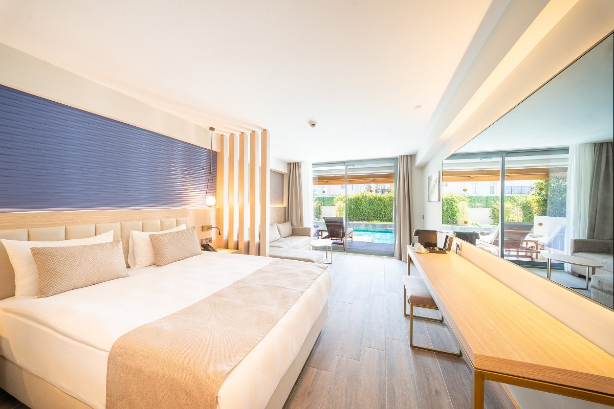 Modern hotel bathroom with glass shower, elegant marble washbasin and high-quality care products.