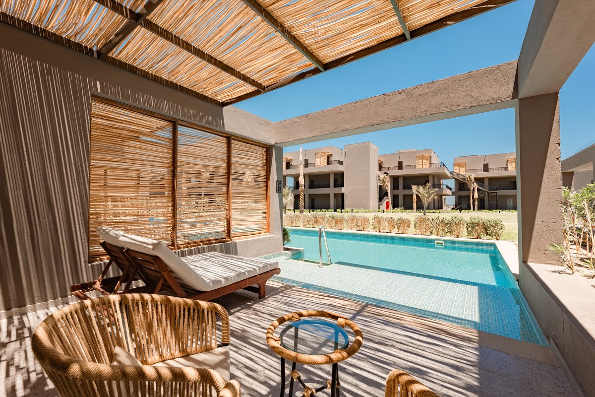 ‘Furnished balcony with sea view, two chairs and table, view of whirlpool and sandy beach