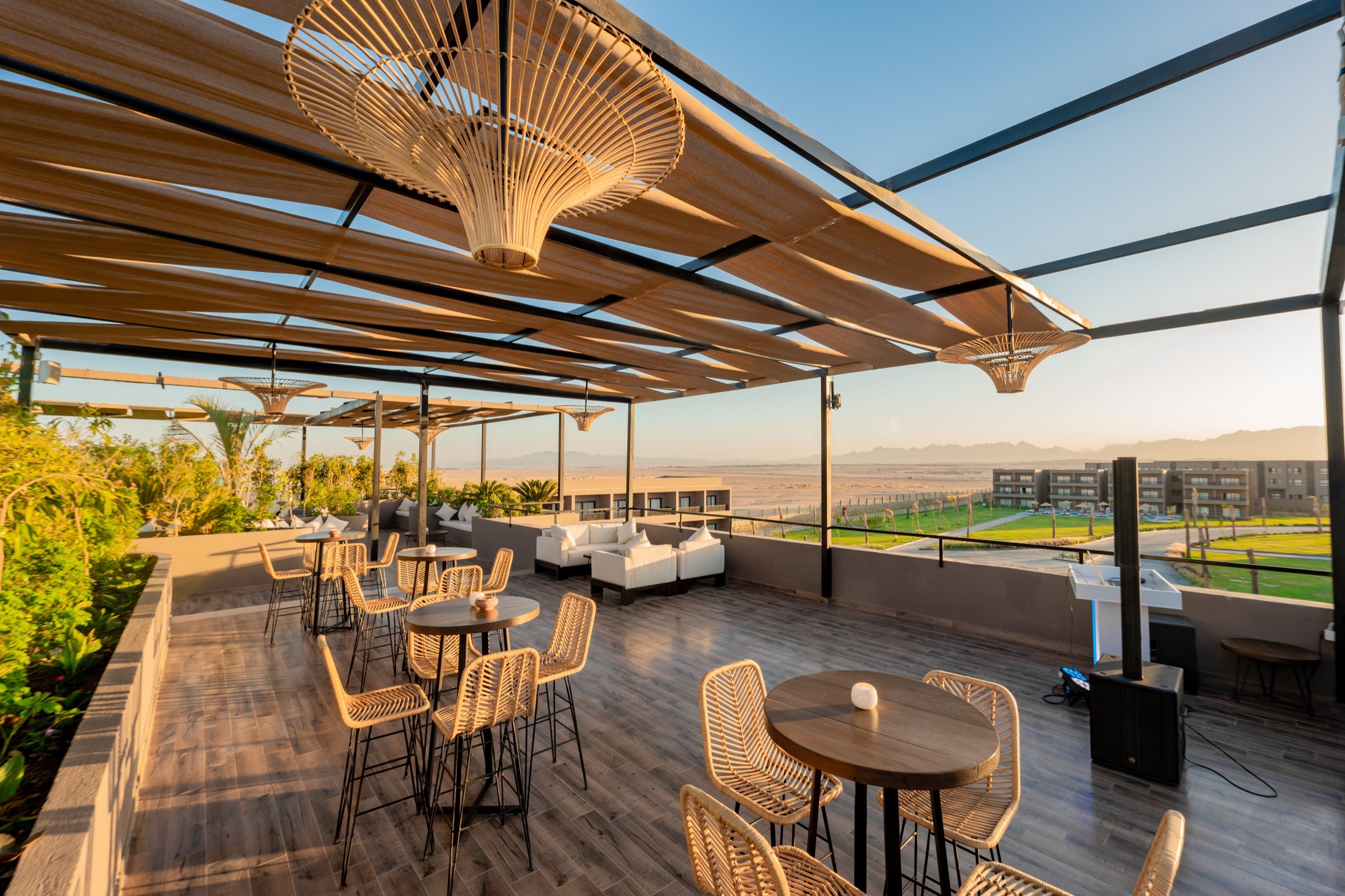Roof terrace with lounge and seating areas, views of the mountains and well-tended gardens at sunset